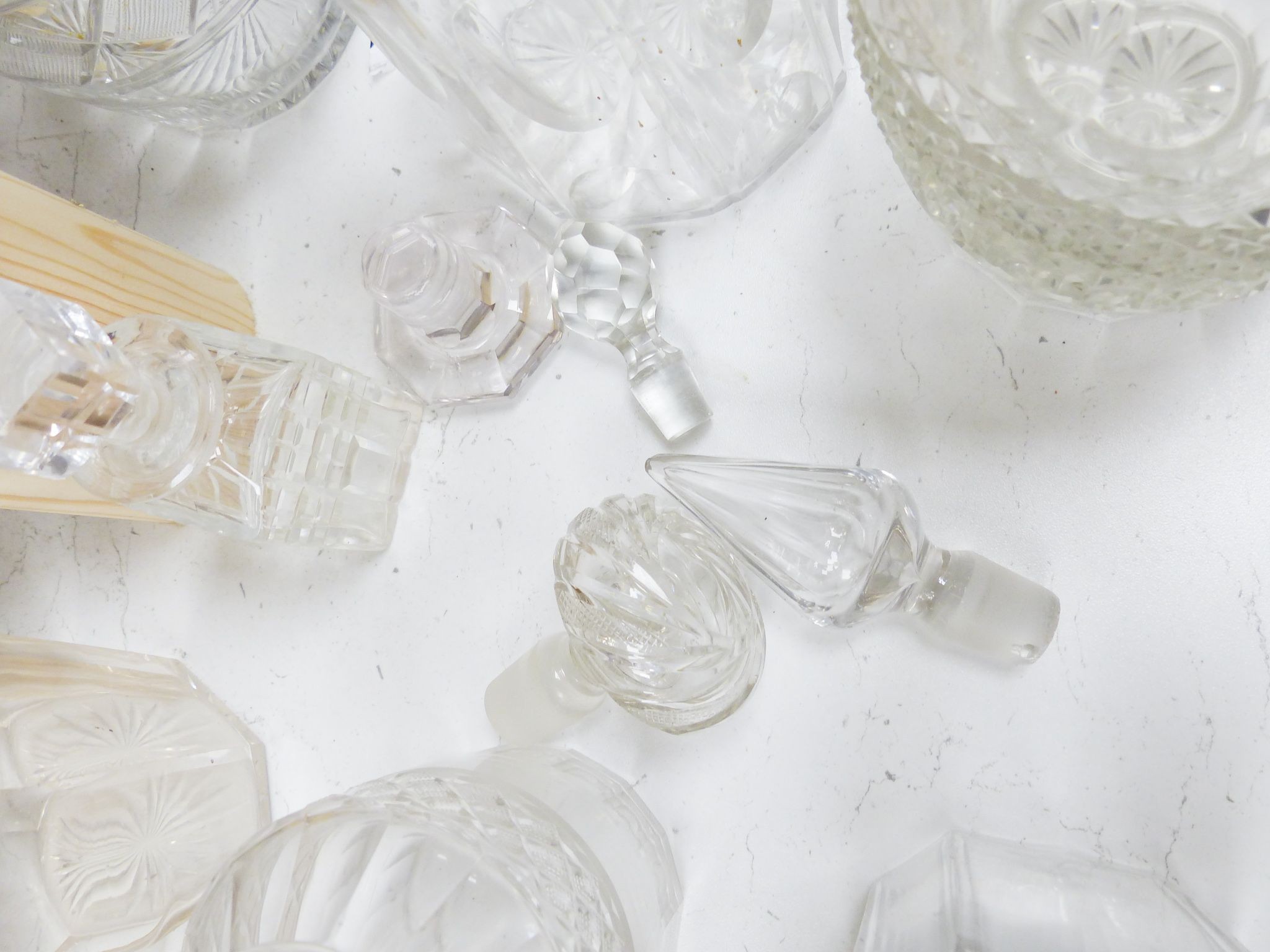 A collection of thirteen cut glass decanters